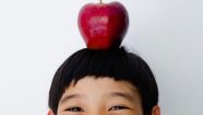 Happy Boy Child Smiling with Apple on His Head