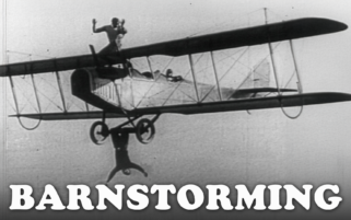 1920s Barnstorming Stock Footage: Wing Walkers & Stunts | Black and white still of 1920s wing walker standing on biplane wing