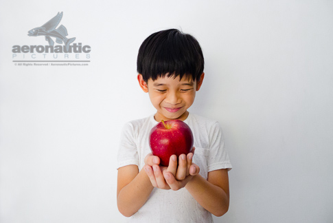 Food Stock Photo - A Happy Kid Smiling and Holding an Apple