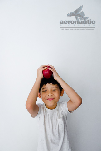 Food Stock Photo - A Happy Kid Holding an Apple Over His Head Download