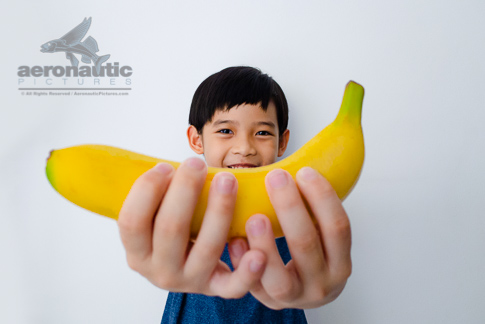 Food Stock Photo - A Happy Kid Holding a Banana Download Royalty Free