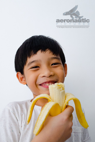 Food Stock Photo - A Happy Kid Holding a Half-eaten Banana Download