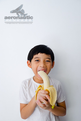 Food Stock Photo - A Kid Eating a Banana - Download Royalty Free!