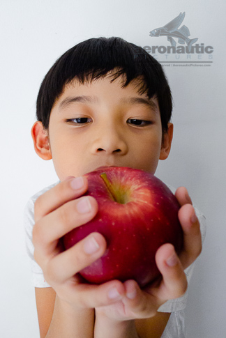Food Stock Photo - A Kid Looking Closely at an Apple Download Royalty Free
