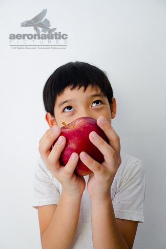 Food Stock Photo - A Kid Thinking and Holding an Apple Download Royalty Free